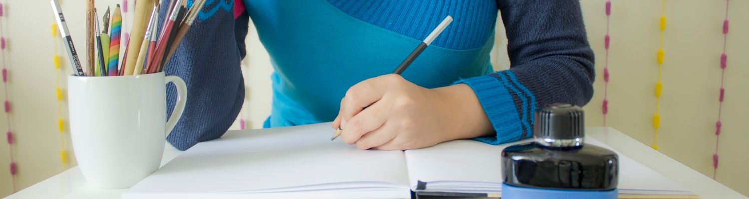 Just for Teens At-Home Activities header: girl in blue sweater at desk with cup of pencils, an open notebook, and a bottle of ink.