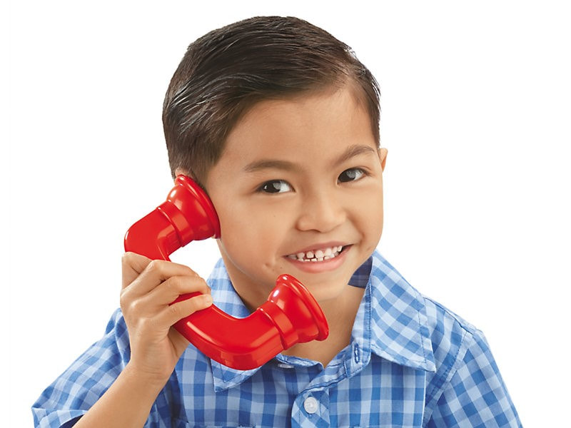 Child holding a large, plastic phone to their ear.